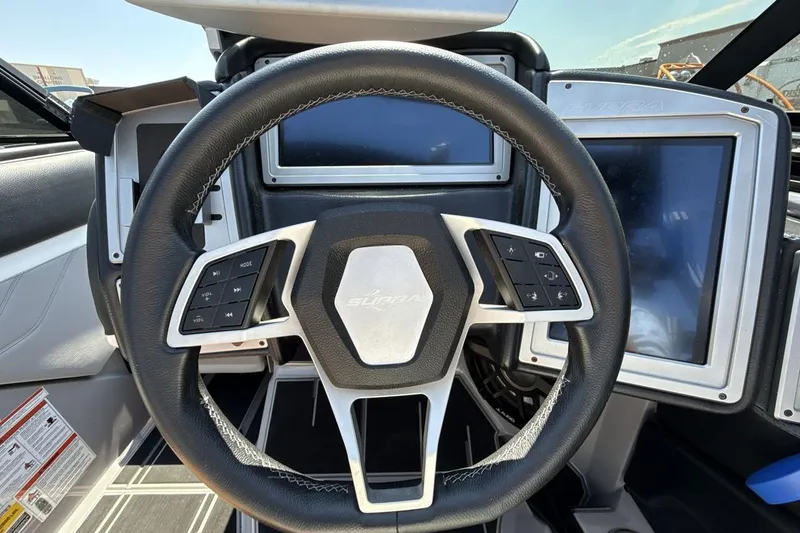 Slide: The Image of Steering wheel of 2023 Supra SE 550 boat with control buttons and digital displays. - 14