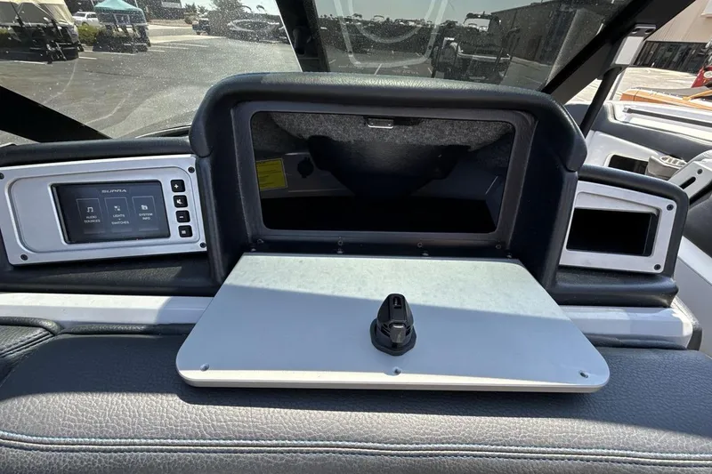 Slide: The Image of 2023 Supra SE 550 dashboard with touchscreen controls and storage compartment. - 18