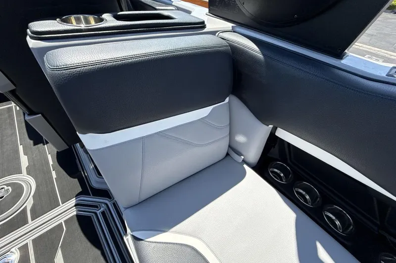 Slide: The Image of 2023 Supra SE 550 interior with sleek black and gray seating and cup holders. - 25