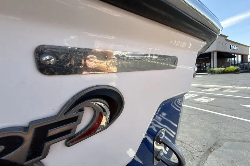 Slide: The Image of 2023 Supra SE 550 boat detail with logo and metal plate in parking lot. - 26