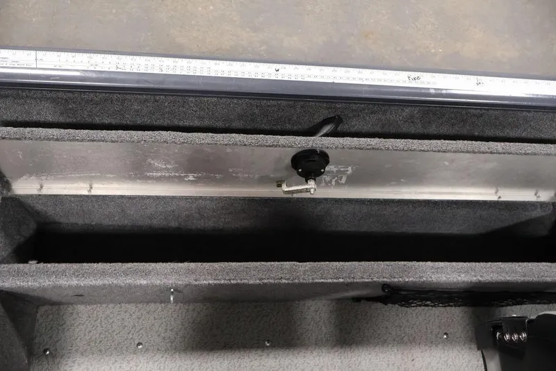 Slide: The Image of 2019 Tracker Pro Guide V-16 SC boat storage compartment with ruler and lock mechanism. - 25