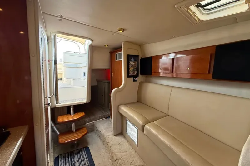 Slide: The Image of Interior of 2005 Rinker Fiesta Vee 300 boat with beige seating and wooden accents. - 10