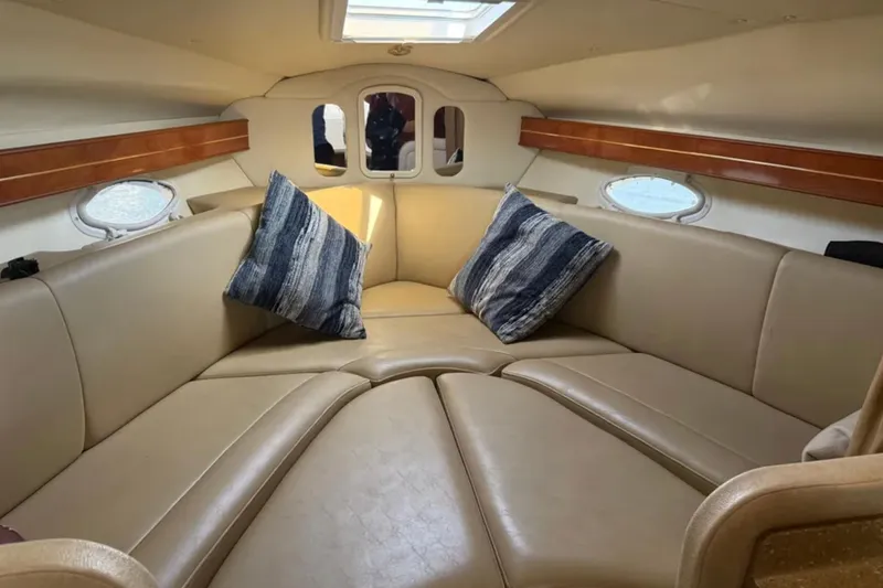 Slide: The Image of Interior of 2005 Rinker Fiesta Vee 300 with beige seating and decorative pillows. - 11
