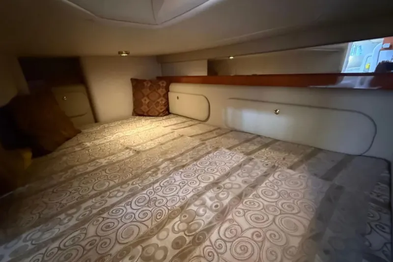 Slide: The Image of Interior cabin of 2005 Rinker Fiesta Vee 300 with patterned bedding and pillows. - 13