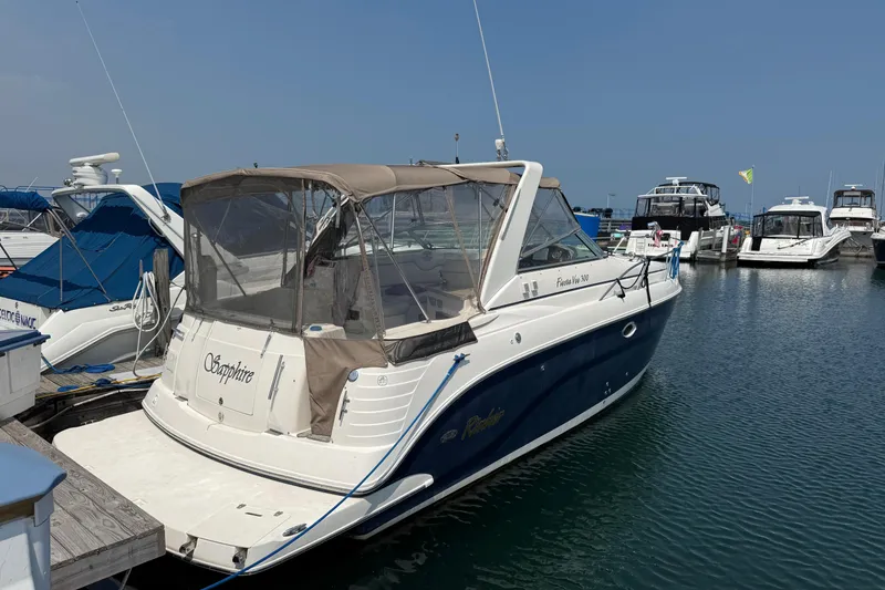 Slide: The Image of 2005 Rinker Fiesta Vee 300 boat docked at marina under clear blue sky. - 2