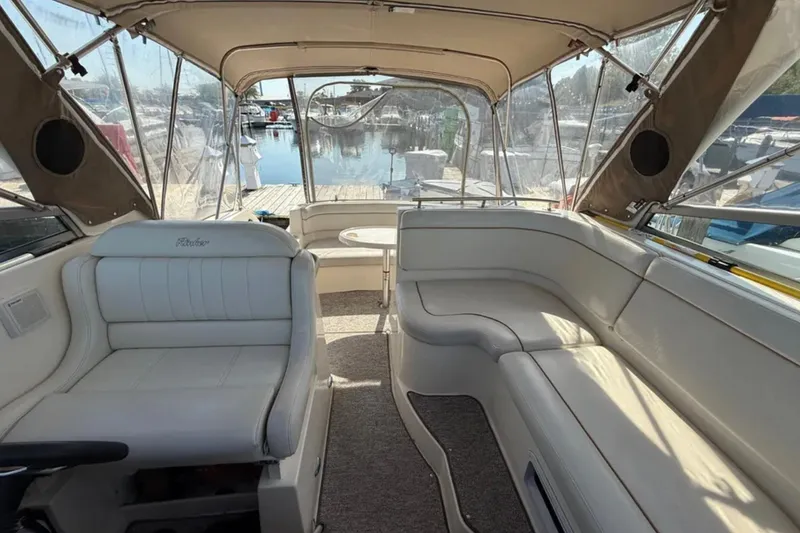 Slide: The Image of 2005 Rinker Fiesta Vee 300 boat interior with beige seating and marina view. - 7