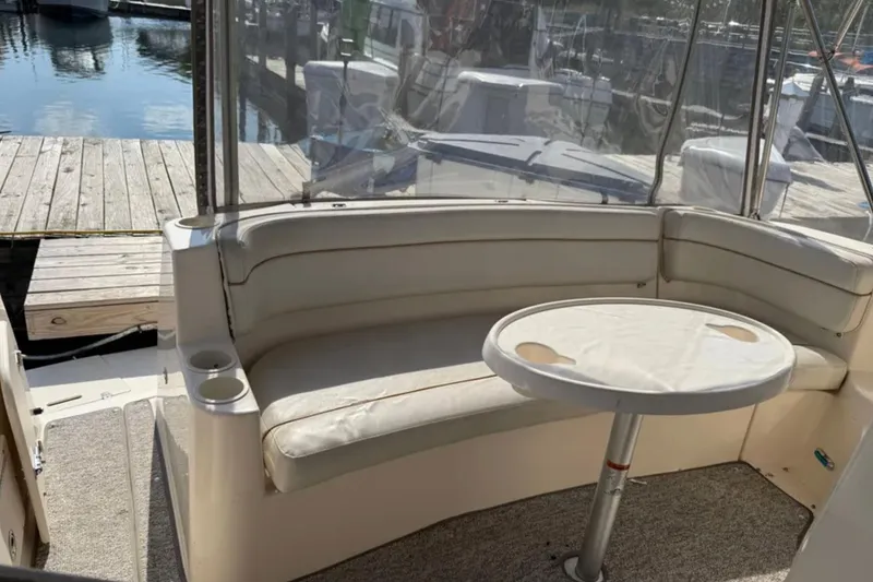 Slide: The Image of 2005 Rinker Fiesta Vee 300 boat interior with seating and table, docked at marina. - 8