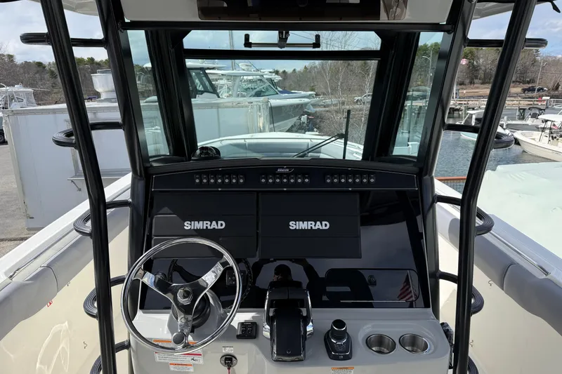 Slide: The Image of 2026 Boston Whaler 330 Outrage helm with Simrad electronics and steering wheel. - 11