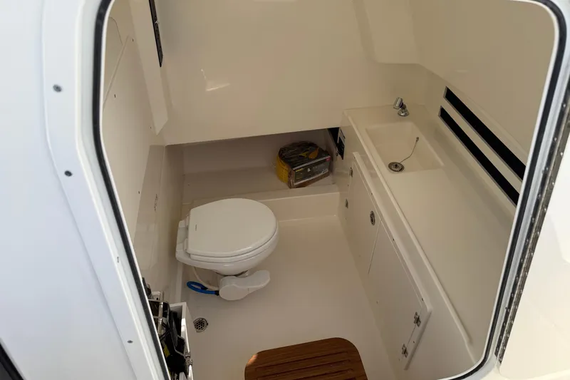 Slide: The Image of 2026 Boston Whaler 330 Outrage boat interior with toilet and sink. - 12