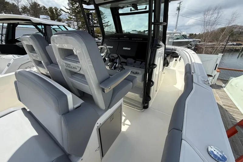 Slide: The Image of 2026 Boston Whaler 330 Outrage boat interior with helm and seating area. - 14
