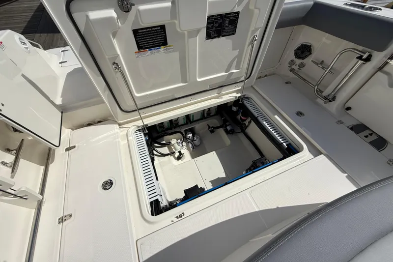 Slide: The Image of Open hatch of 2026 Boston Whaler 330 Outrage boat, revealing internal components and storage. - 15