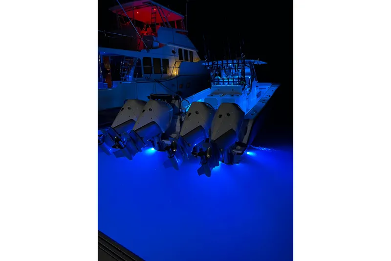 Slide: The Image of 2022 Freeman 37VH boat with illuminated blue underwater lights at night. - 37