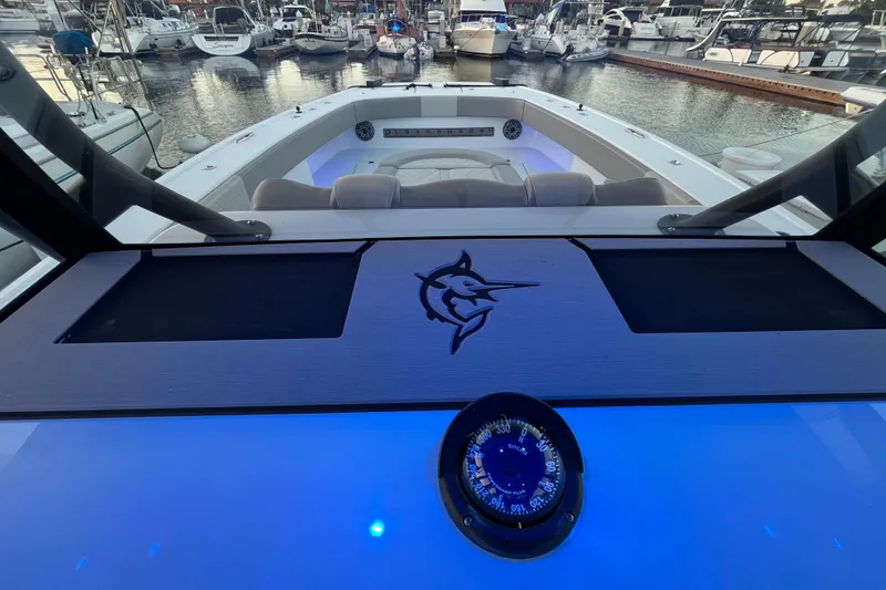 Slide: The Image of Freeman 37VH 2022 boat dashboard with compass, marina view in background. - 8