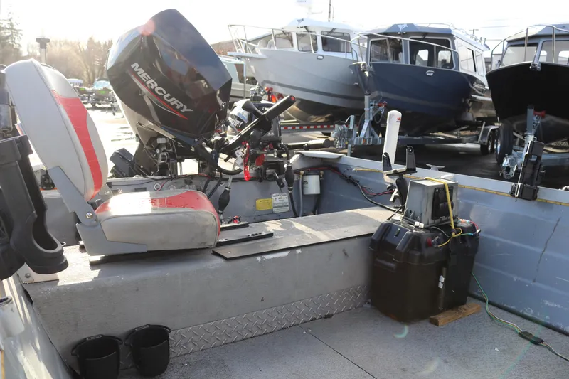 Slide: The Image of 1997 Starcraft Patriot 160 boat interior with Mercury outboard motor, docked near other boats. - 8