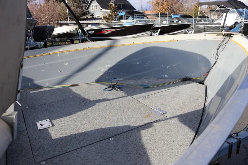 Slide: The Image of 1997 Starcraft Patriot 160 boat interior with gray flooring and visible wiring. - 9