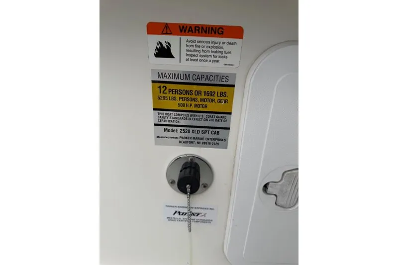 Slide: The Image of Warning label on 2015 Parker 2520XLD boat, showing maximum capacity and safety information. - 18