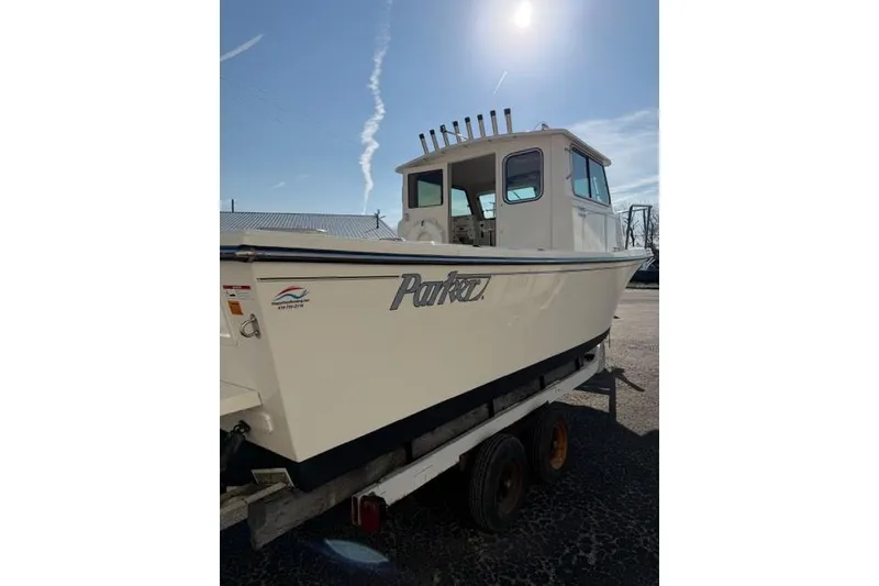 Slide: The Image of 2015 Parker 2520XLD boat on trailer under clear blue sky. - 2
