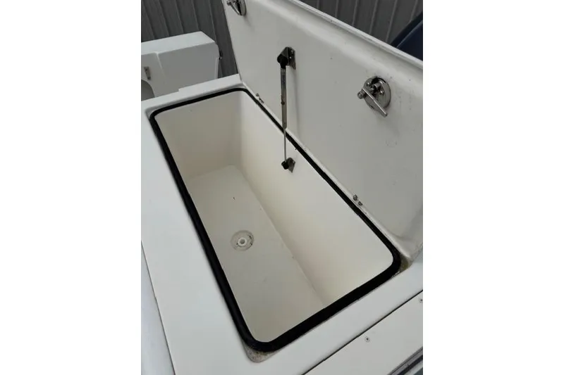 Slide: The Image of Open storage compartment on a 2015 Parker 2520XLD boat, featuring a clean interior. - 23