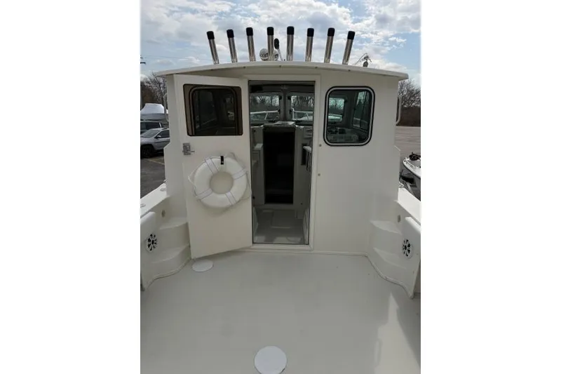 Slide: The Image of 2015 Parker 2520XLD boat with open cabin door and rod holders. - 27