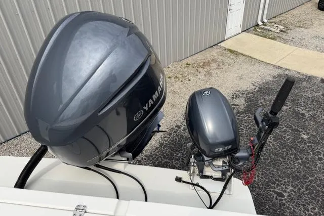 Slide: The Image of Yamaha outboard motors on a 2015 Parker 2520XLD boat, parked near a metal building. - 28