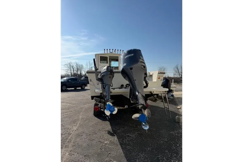 Slide: The Image of 2015 Parker 2520XLD boat with dual outboard motors in a sunny outdoor setting. - 29