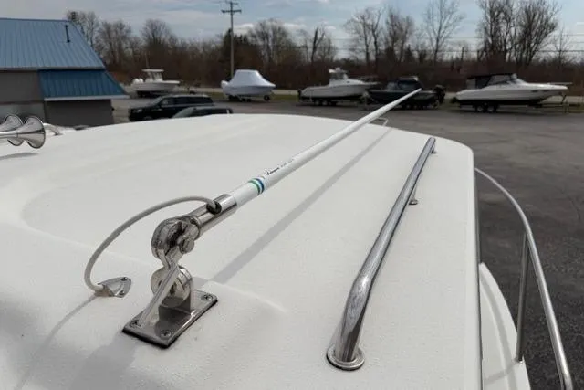 Slide: The Image of 2015 Parker 2520XLD boat rooftop with antenna and railing, parked near other boats. - 5