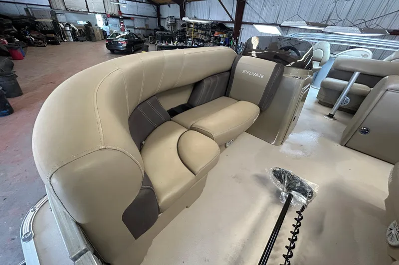 Slide: The Image of 2021 Sylvan Mirage Fish 820 CNF pontoon boat interior with beige seating in a warehouse. - 10