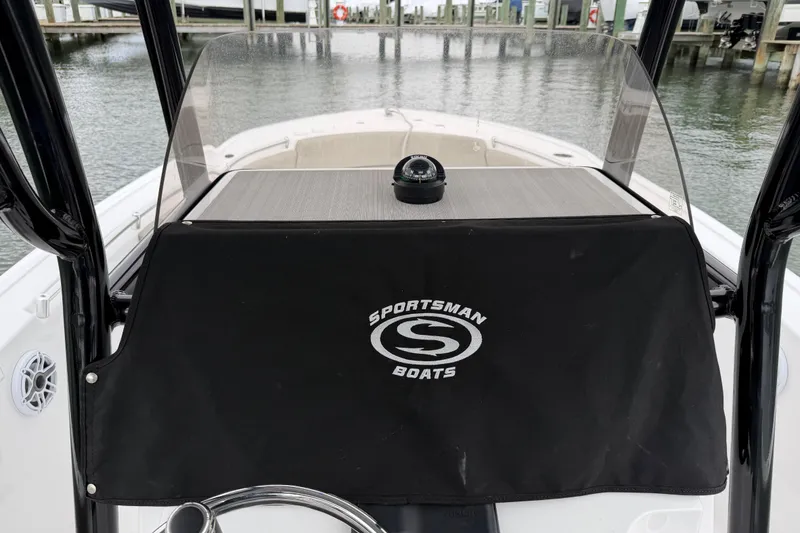 Slide: The Image of 2022 Sportsman Heritage 241 Center Console boat dashboard with compass and protective cover. - 23