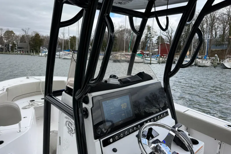 Slide: The Image of 2022 Sportsman Heritage 241 Center Console boat with modern dashboard on a scenic waterfront. - 28