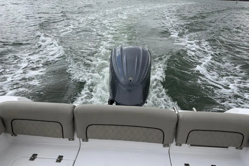 Slide: The Image of 2022 Sportsman Heritage 241 Center Console boat on water, rear view with motor. - 30