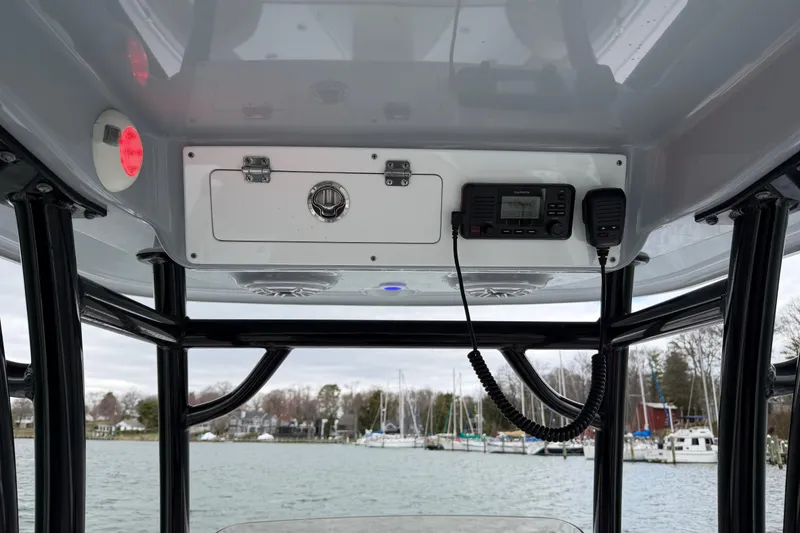 Slide: The Image of 2022 Sportsman Heritage 241 Center Console boat interior with radio and storage compartment. - 31