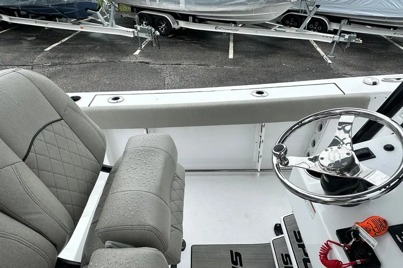Slide: The Image of 2022 Sportsman Heritage 241 Center Console boat interior with steering wheel and seating. - 9
