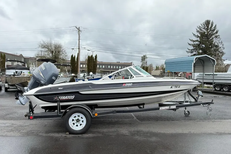 Slide: The Image of 1996 Stratos 283 FS boat on trailer with Yamaha outboard motor, parked outdoors. - 3