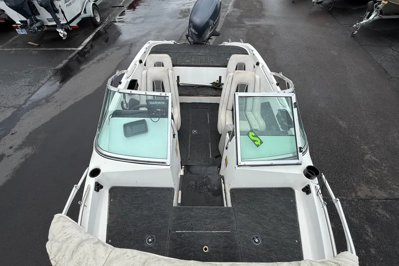 Slide: The Image of 1996 Stratos 283 FS boat interior with seating and windshield, parked on wet pavement. - 5