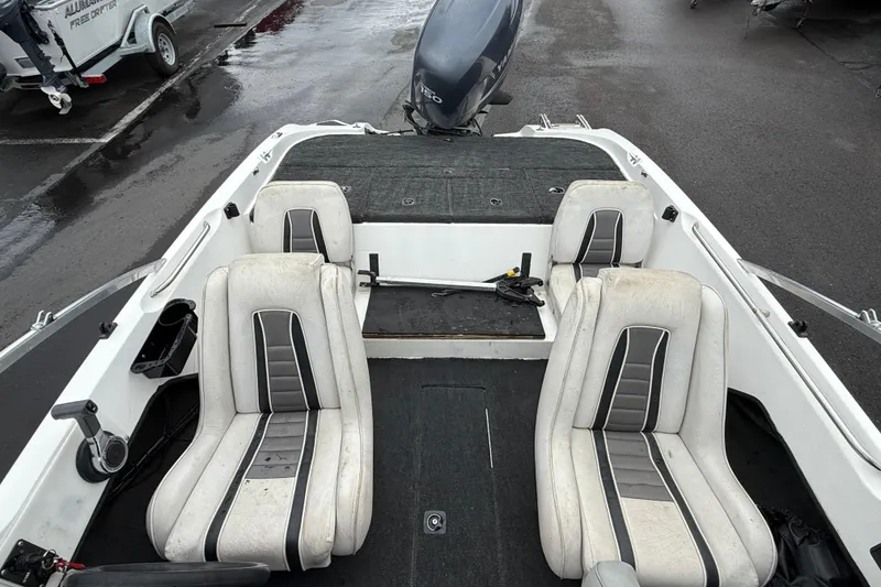 Slide: The Image of 1996 Stratos 283 FS boat interior with dual seats and motor, parked on wet pavement. - 6