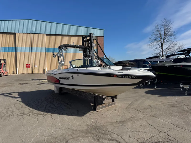 Slide: The Image of 2016 MasterCraft X30 boat on a parking lot under sunny skies. - 1