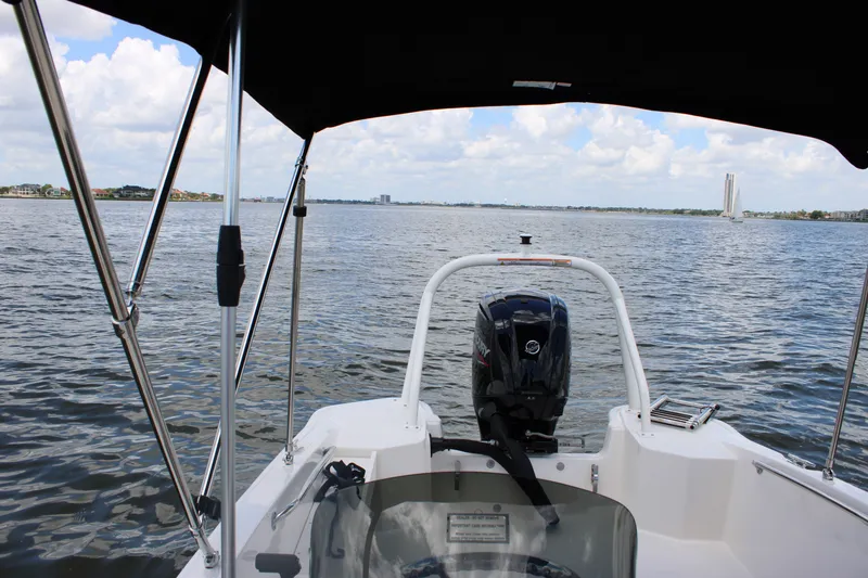 Slide: The Image of View from the helm of a Boston Whaler 160 Super Sport overlooking the water, featuring an outboard motor. - 14