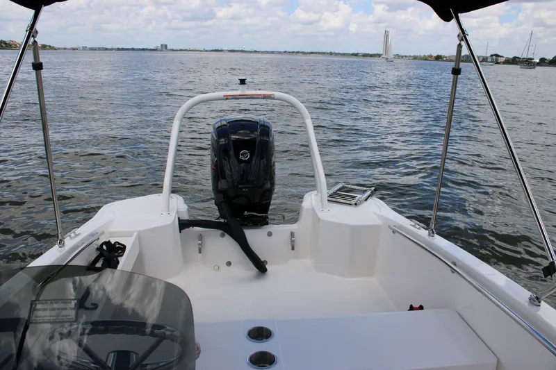Slide: The Image of View from the cockpit of a Boston Whaler 160 Super Sport overlooking the water, with engine and bimini top. - 16