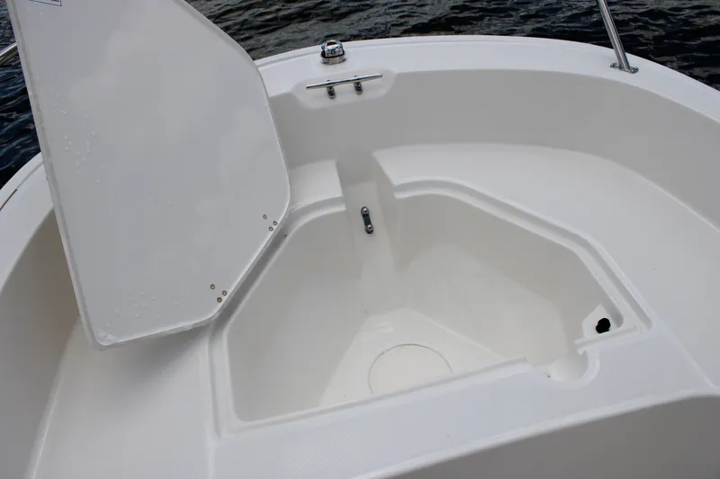 Slide: The Image of An open storage compartment on a Boston Whaler 160 Super Sport boat, with water in the background. - 20