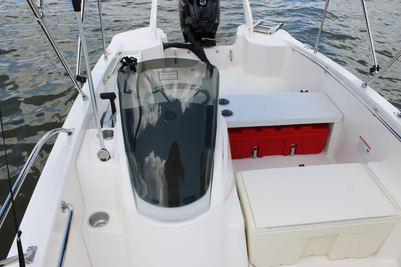 Slide: The Image of Boston Whaler 160 Super Sport 2026 with sleek cockpit and red storage on calm water. - 17