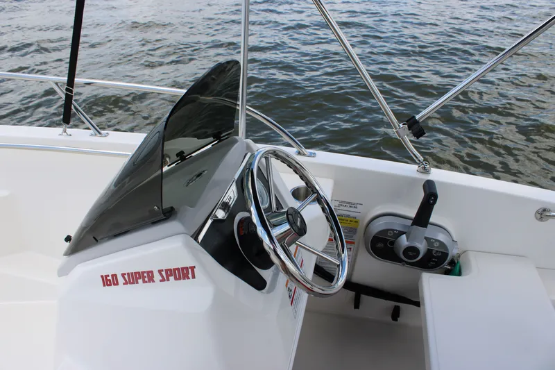 Slide: The Image of The image shows the helm of a 2026 Boston Whaler 160 Super Sport with a steering wheel and throttle. - 24