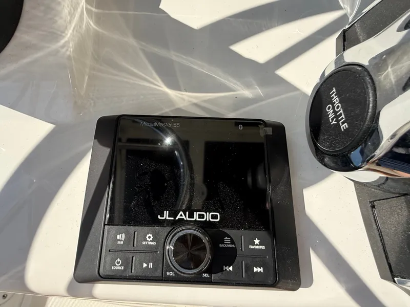 Slide: The Image of A JL Audio MediaMaster 55 control unit next to a throttle lever on a boat. - 11