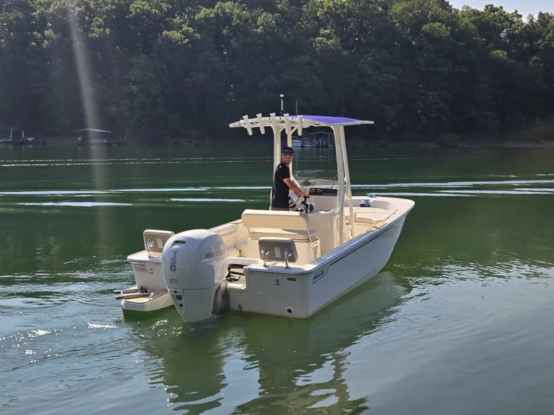 Slide: The Image of A 2026 Boston Whaler 190 Montauk on a calm lake with a wooded shoreline. - 5