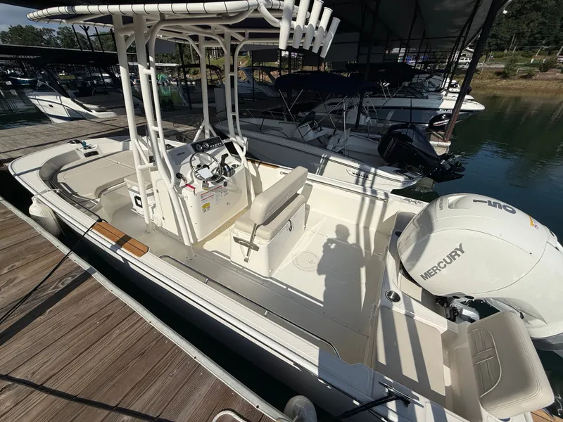 Slide: The Image of A 2026 Boston Whaler 190 Montauk docked. It features an open deck and a Mercury engine. - 9