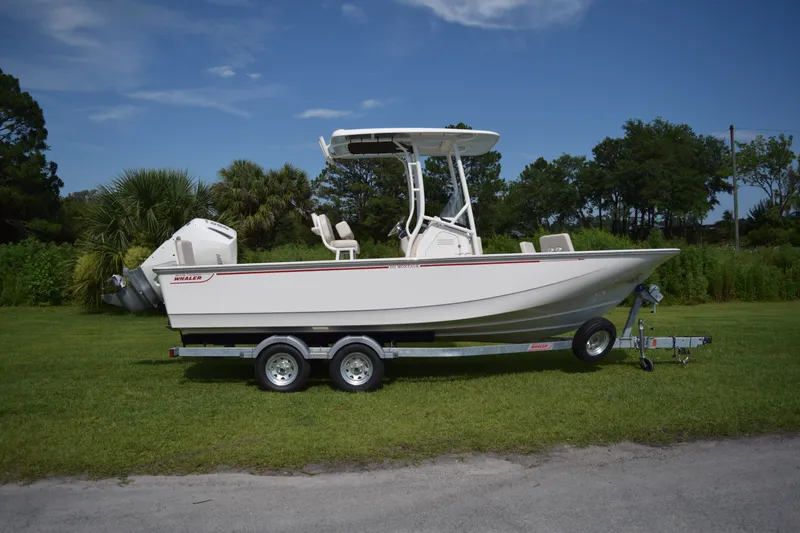 Slide: The Image of A 2026 Boston Whaler 210 Montauk sits on a trailer on a grassy area. - 0