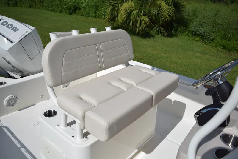 Slide: The Image of The 2026 Boston Whaler 210 Montauk features a cushioned bench seat with cup holders and a helm station. - 11