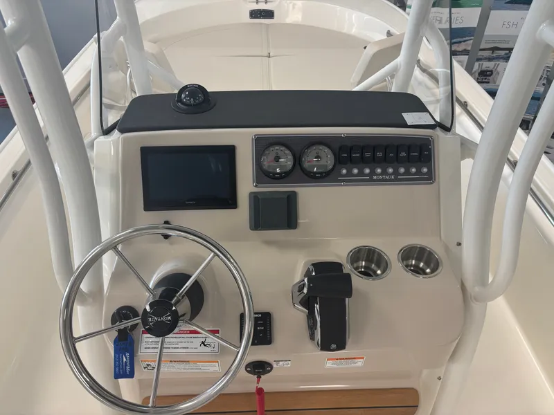 Slide: The Image of The image shows the helm of a Boston Whaler 210 Montauk with a steering wheel and instruments. - 7