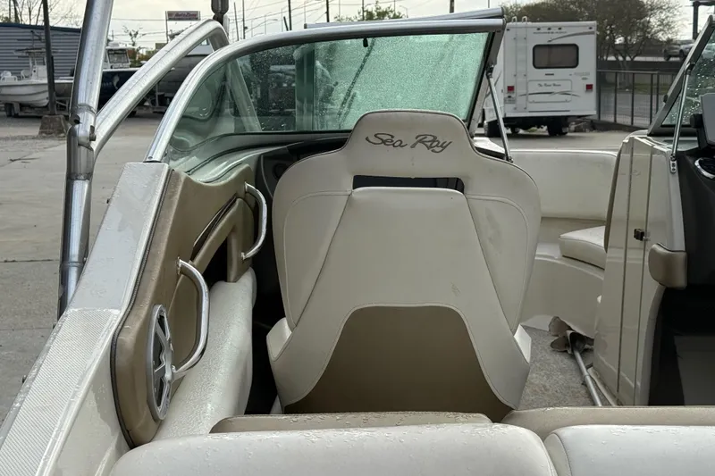 Slide: The Image of 2007 Sea Ray 210 Dual Console boat interior with beige seating and windshield. - 11
