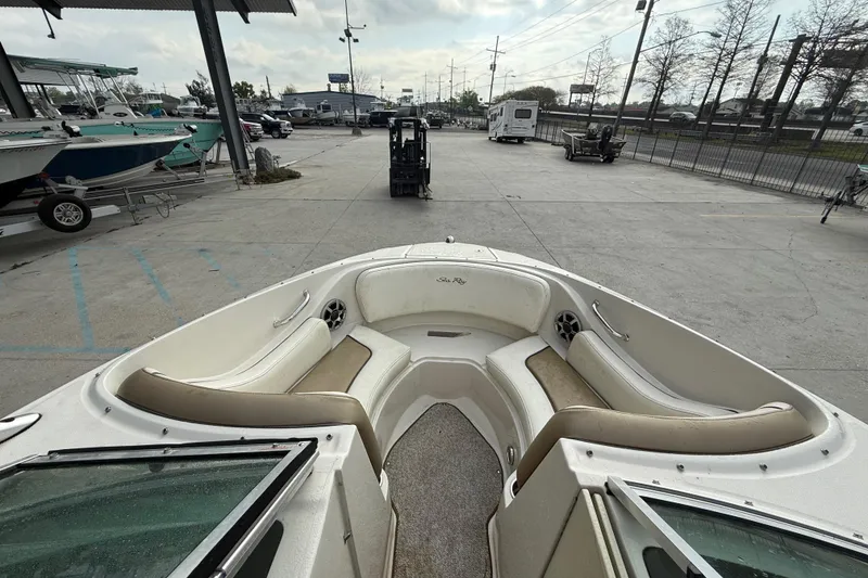 Slide: The Image of 2007 Sea Ray 210 Dual Console boat interior with seating, parked in a marina. - 13