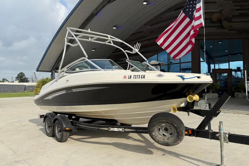 Slide: The Image of 2007 Sea Ray 210 Dual Console boat on trailer, American flag in background. - 2